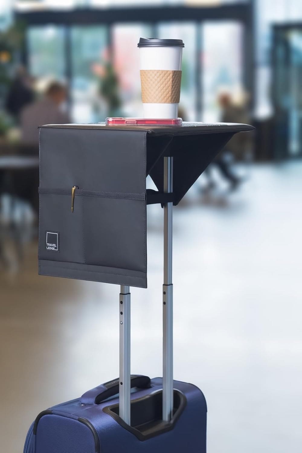 Travel Ledge holding a drink and phone on rolling luggage